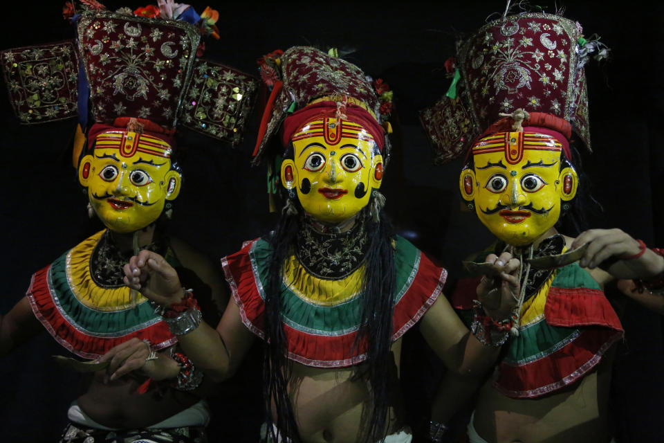 In this Sept. 23, 2018, photo, dancers pose for photographs wearing the mask of god Betal in Kathmandu, Nepal. For centuries, Nepal has celebrated the Indra Jatra festival of masked dancers, which officially begins the month-long festivities in the Hindu-dominated Himalyan nation. The dancers, who come from a variety of backgrounds, pull off this performance every year despite minimal financial support from the government and other sources, they say. (AP Photo/Niranjan Shrestha)