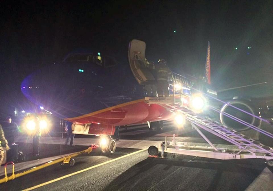 In this Sunday, Jan. 12, 2014 photo provided by Scott Schieffer, rescue personnel help passengers off a Southwest Airlines flight that was supposed to land at Branson Airport in Branson, Mo., but instead landed at Taney County Airport, in Hollister, Mo., that only has about half as much runway. A Southwest spokesman said all 124 passengers and five crew members were safe. (AP Photo/ Scott Schieffer) MANDATORY CREDIT