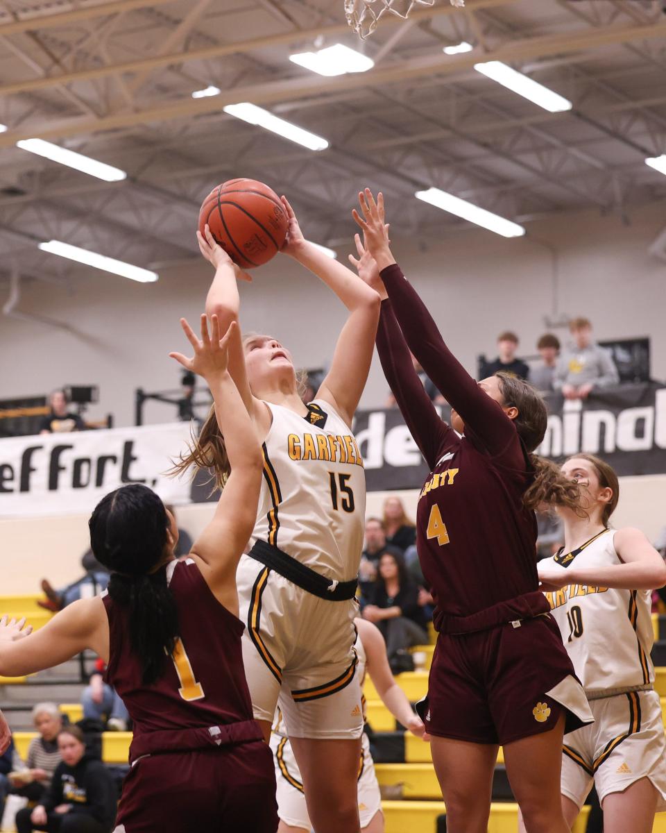 Garfield senior guard Nora Trent pulls down a rebound during Thursday night's basketball game against the Liberty Leopards at James A. Garfield High School.