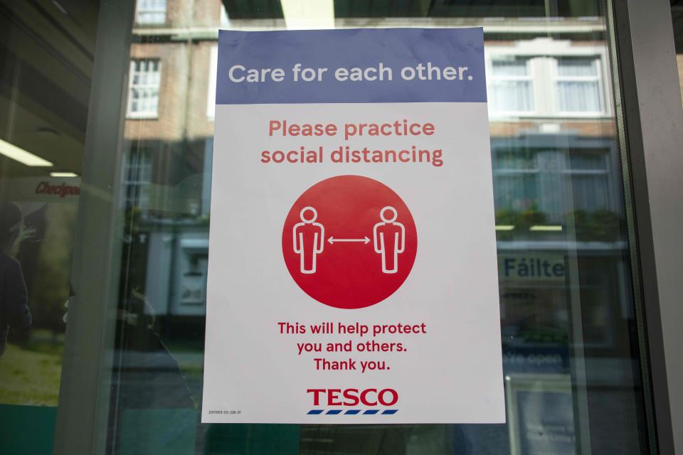 A sign outside a branch of a Tesco supermarket alerts customers for the need to obey social distancing measures, in Dublin, on March 25, 2020, after Ireland introduced measures to help slow the spread of the novel coronavirus. - Ireland's prime minister Leo Varadkar on Tuesday announced that all non-essential businesses will shut from midnight  as part of the country's latest measures to tackle the coronavirus outbreak. "These are unprecedented actions to respond to an unprecedented emergency," he said, adding the measures would remain in place until at least April 19. (Photo by PAUL FAITH / AFP) (Photo by PAUL FAITH/AFP via Getty Images)