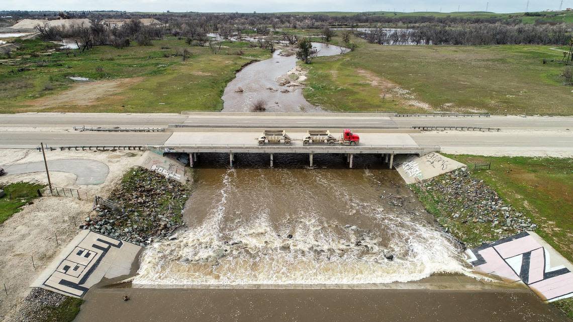 Water swells along the banks of the Little Dry Creek overflow while moving toward the San Joaquin River near Ball Ranch on North Friant Road on Wednesday, March 8, 2023.