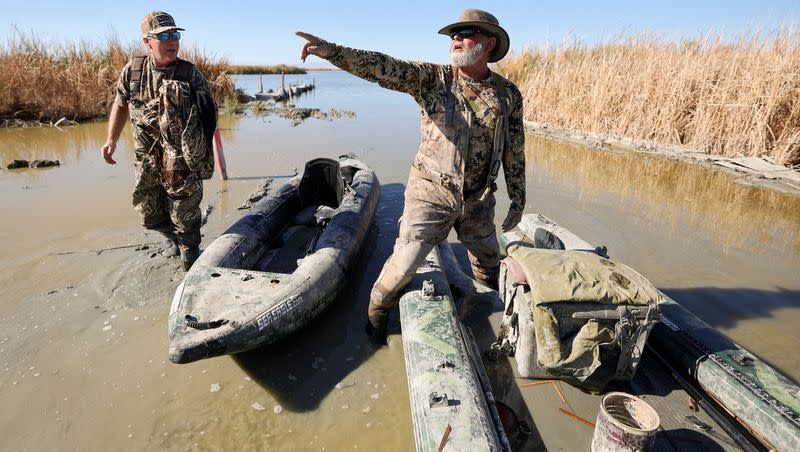 David Williams listens to his duck hunting guide Breck Dickinson as they get ready to load their boats into a truck near Red Hill Park, in Imperial County, Calif., on Tuesday, Dec. 12, 2023. Dickinson has been hunting in the area for around 30 years and has watched the bird populations change along with changing water levels of the Salton Sea. He also said brown pelicans disappeared as fish in the lake died off, eliminating their food source.