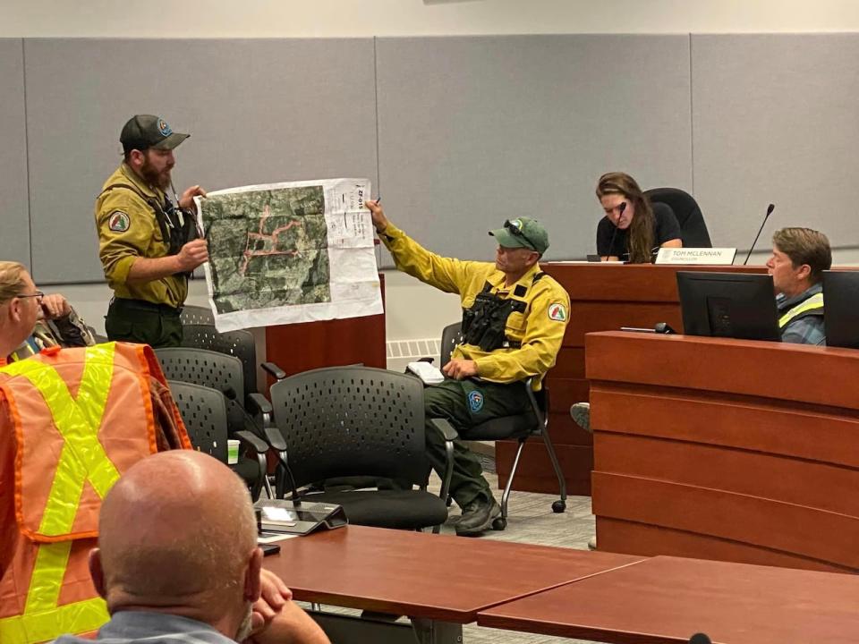 N.W.T. firefighters discuss the construction of a fire break to protect Yellowknife from an approaching wildfire. (Submitted by Chris Greencorn - image credit)