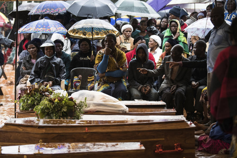 People attend the burial ceremony of some of the people who lost their lives following heavy rains caused by Cyclone Freddy in Blantyre, southern Malawi, Wednesday, March 15, 2023. After barreling through Mozambique and Malawi since late last week and killing hundreds and displacing thousands more, the cyclone is set to move away from land bringing some relief to regions who have been ravaged by torrential rain and powerful winds. (AP Photo/Thoko Chikondi)