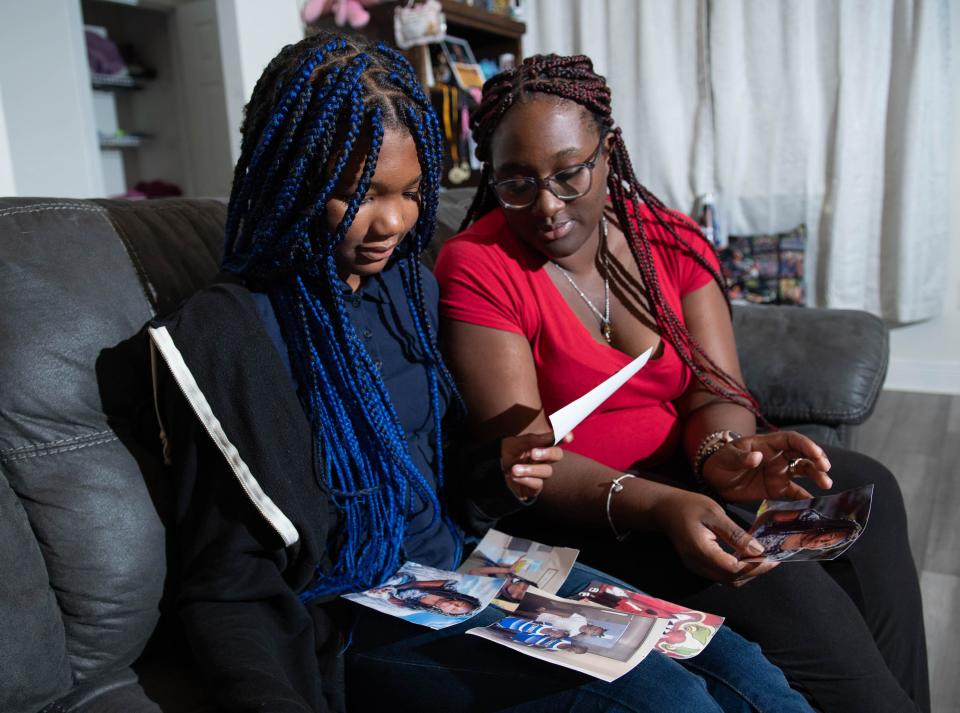 Jackie Williams, right, and her daughter Navaeh Williams, 13, look through photos of her other daughter Kaliyah Williams at their home in Milton on Thursday, Sept. 28, 2023. Fourteen-year-old Kaliyah took her own life in April.