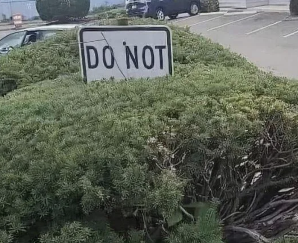 Sign partially obscured by bushes reads "DO NOT." Full instruction unclear