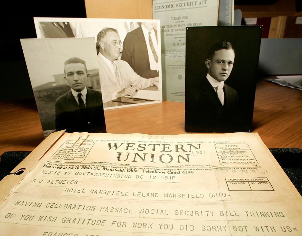 A photo taken Aug. 11, 2005, in Madison, Wis., at the Wisconsin Historical Society shows a telegram dated Aug. 12, 1935, in which Labor Secretary Frances Perkins congratulates Arthur Altmeyer on the Social Security Act, which President Franklin D. Roosevelt signed into law on Aug. 14, 1935, pictured top center. Altmayer, left, and Edwin Witte, right, were University of Wisconsin economists who were instrumental in drafting and shepherding the Social Security Act.
