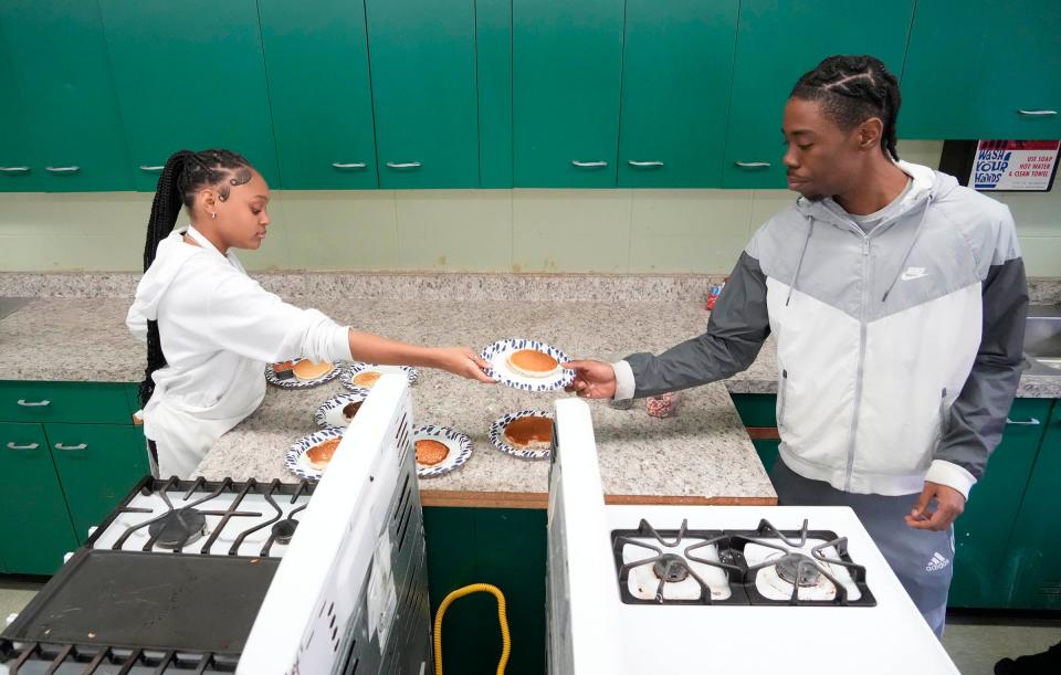 Students pass out pancakes in the culinary classroom at James Madison High School.