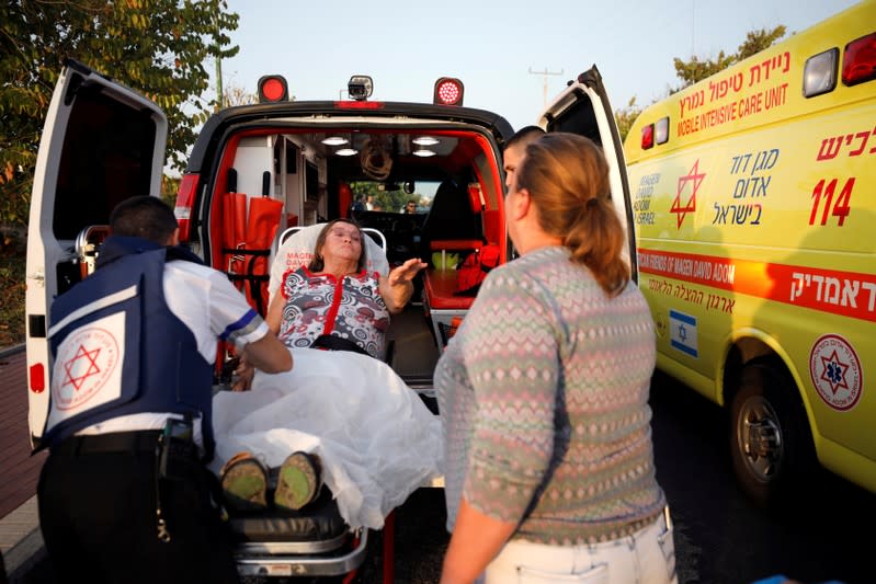 An injured woman is evacuated to hospital after a rocket was fired from Gaza into Israel, in Ashkelon, southern Israel