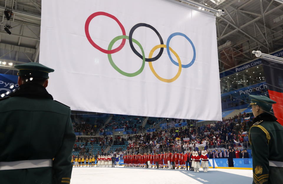 Olympic Athletes from Russia wear their gold medals under the Olympic flag during the victory ceremony.