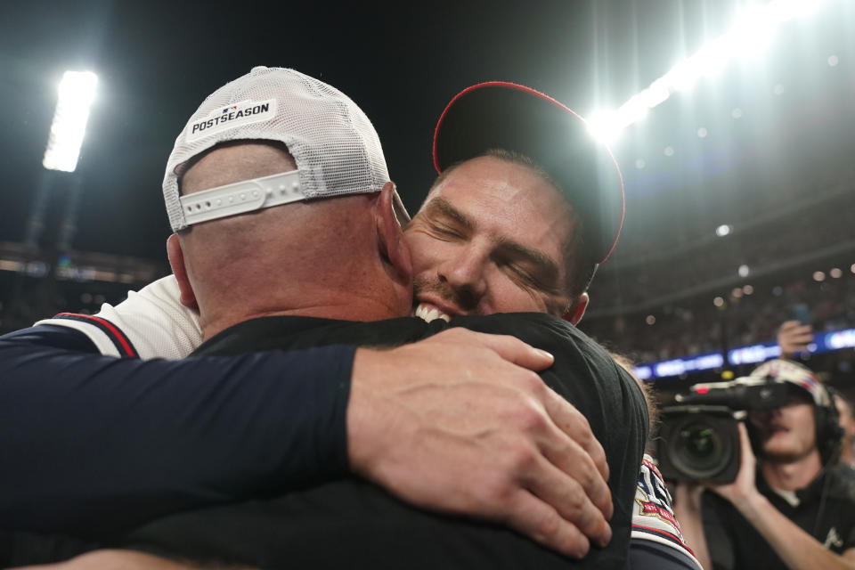 Atlanta Braves Freddie Freeman embraces Atlanta Braves manager Brian Snitker after Game 4 of a baseball National League Division Series against the Milwaukee Brewers, Tuesday, Oct. 12, 2021, in Atlanta. The Atlanta Braves won 5-4 to advance to the NLCS. (AP Photo/Brynn Anderson)