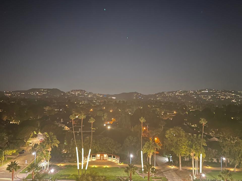 The view at Sant'olina in Beverly Hills overlooking the mountains of Los Angeles and palm trees.