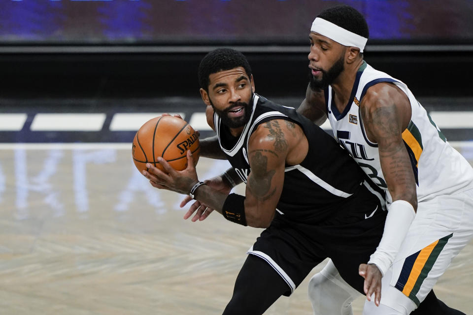 FILE - Utah Jazz's Royce O'Neale, right, defends Brooklyn Nets' Kyrie Irving (11) during the first half of an NBA basketball game in New York, in this Tuesday, Jan. 5, 2021, file photo. Kyrie Irving rejoined the Brooklyn Nets on Tuesday, Jan. 19, 2021, saying he took a leave of absence because he “just needed a pause.” Irving practiced with the team and could play Wednesday in Cleveland. (AP Photo/Frank Franklin II, File)
