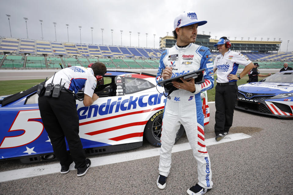 Kyle Larson, front, waits for the start of qualifying for the NASCAR Cup Series auto race at Kansas Speedway in Kansas City, Kan., Saturday, Sept. 10, 2022. (AP Photo/Colin E. Braley)
