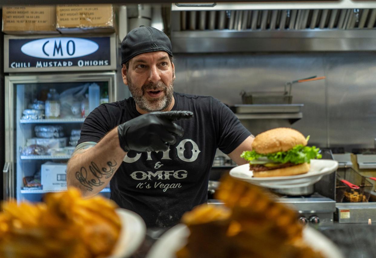 Chili Mustard Onions owner Pete LaCombe prepares an order for a customer while working in the kitchen of the vegan Coney Island restaurant in Detroit on Thursday, September 22, 2022. Pete has had to cut down the amount of days the restaurant is open from six to four days and has had to cut his staff significantly many other vegan restaurants in the city have either downsized or closed altogether during the pandemic.  He also struggles to afford the cost of vegan goods, such as plant-based meat which is not subsidized or sold in bulk like traditional ground beef.