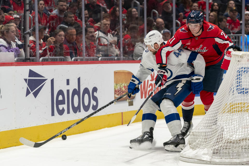 Tampa Bay Lightning defenseman Calvin de Haan (44) and Washington Capitals center Aliaksei Protas (21) compete for control of the puck during the second period of an NHL hockey game Saturday, Dec. 23, 2023, in Washington. (AP Photo/Stephanie Scarbrough)