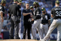 Chicago White Sox starting pitcher Johnny Cueto, center, rehydrates during an evaluation mound visit in the sixth inning of a baseball game against the New York Yankees, Sunday, May 22, 2022, in New York. (AP Photo/John Minchillo)