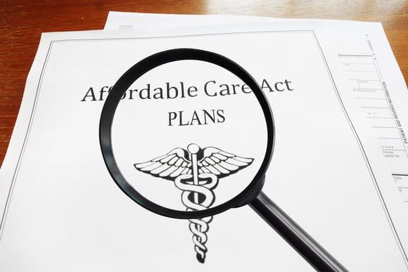 A magnifying glass held over an Affordable Care Act plan.