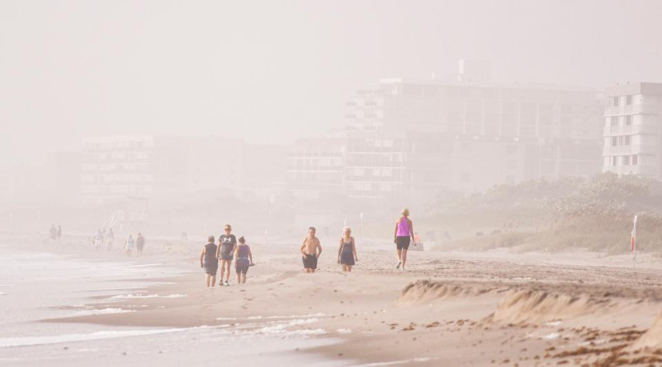 Condos disappear in the distance for beachgoers walking the beach in Cocoa Beach Tuesday. Smoke from the Canadian wildfires has blanketed Florida with haze and air quality alerts have been issued for people with health issues.