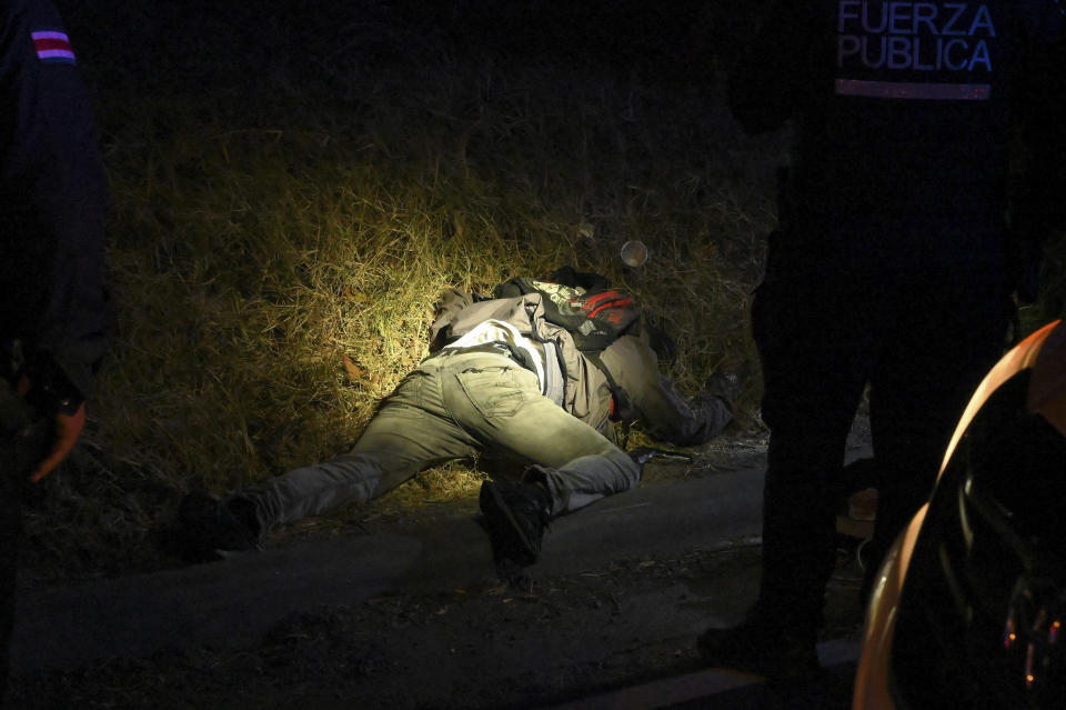 FILE - The body of a man is illuminated by police flashlights as investigators work a crime scene where an alleged thief and a female passenger died in a shootout during a robbery on a bus in San Jose, Costa Rica, Feb. 6, 2023. President Rodrigo Chavez, who took office in 2022, has promised more police in the street and tougher laws to take on the uptick in crime. (AP Photo/Carlos Gonzalez, File)
