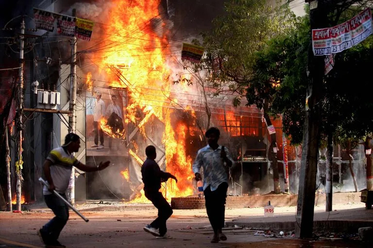 Un grupo de delincuentes no identificados prende fuego a una tienda de ropa en Dhaka el 4 de agosto de 2024.