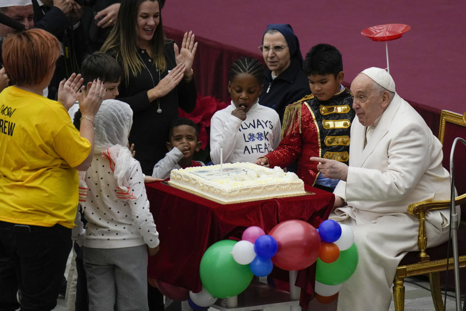 Pope Francis is offered a cake as he celebrates his birthday with children assisted by the Santa Marta dispensary during an audience in the Paul VI Hall, at the Vatican, Sunday, Dec. 17, 2023. Pope Francis turnes 87 on Dec.17. (AP Photo/Alessandra Tarantino)