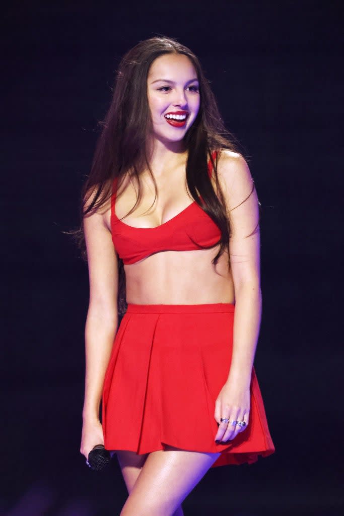 Olivia smiling on stage with microphone
