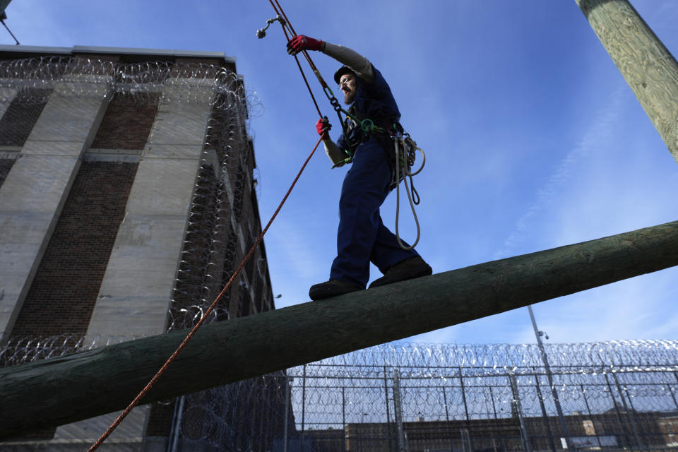 Prisoner Scott Steffes works on climbing at the Parnall Correctional Facility's Vocational Village in Jackson, Mich., Thursday, Dec. 1, 2022. Steffes, 37, whose release date is Jan. 17, 2023, is one of more than a dozen prisoners learning how to climb trees and trim branches around power lines as part of DTE Energy's plan to improve the utility's electric infrastructure. (AP Photo/Paul Sancya)