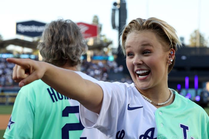 JoJo smiling and pointing at a baseball game