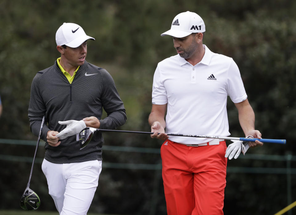 FILE - Rory McIlroy, left, of Northern Ireland, and Sergio Garcia, of Spain, walk up the 15th fairway during a practice round for the Masters golf tournament April 5, 2017, in Augusta, Ga. McIlroy, in a lengthy interview in the Sunday Independent in Ireland, says his close friendship with Garcia ended over a testy text exchange at the U.S. Open. (AP Photo/Matt Slocum, File)