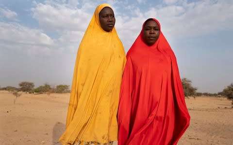 Nigerian refugee Kakahajja Abatcha (in red) takes a walk with her friend Hadiza Abakar - Credit: Simon Townsley/The Telegraph