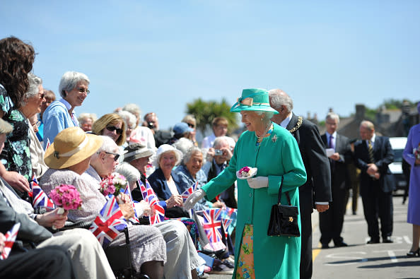 Queen Elizabeth II meets elderly wellwishers on Holgates Green in Hugh Town St Mary's Island in the Isles of Scilly during her visit today.   (Photo by Tim Ireland/PA Images via Getty Images)