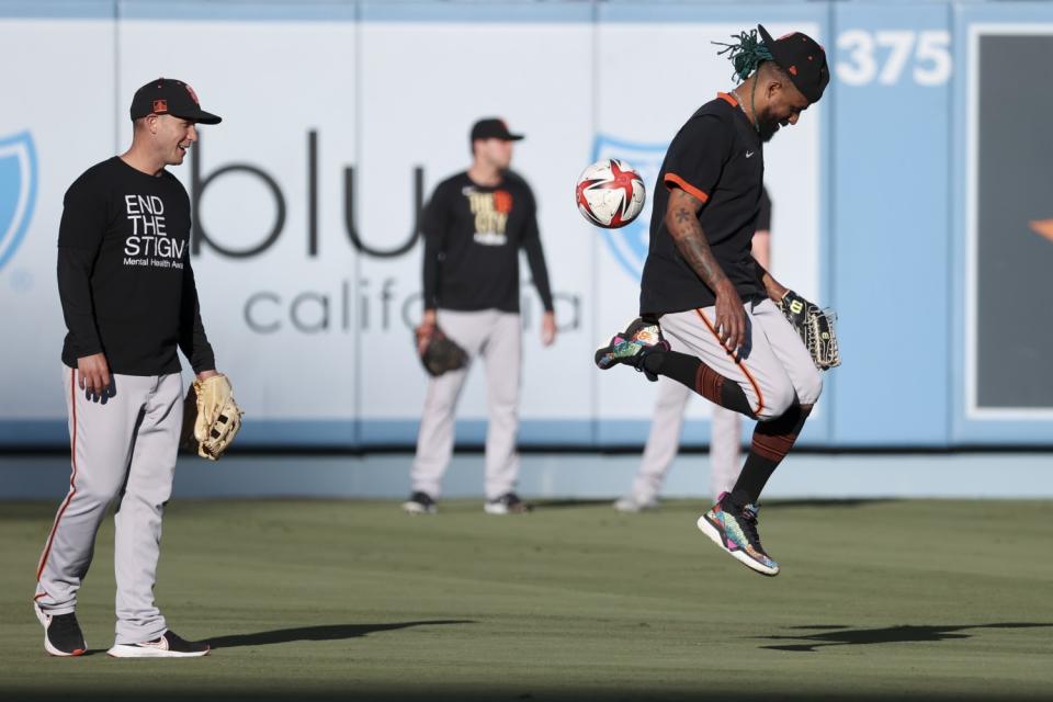 Giants' Camilo Doval kicks around a soccer ball.