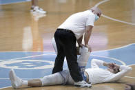 North Carolina trainer Doug Halverson stretches North Carolina forward Walker Kessler prior to the team's NCAA college basketball game against Syracuse in Chapel Hill, N.C., Tuesday, Jan. 12, 2021. College athletic trainers have busy lives, trying to keep up with student-athletes' injuries, rehab and making sure they get to doctor's appointments. The coronavirus pandemic has added another layer of work. (AP Photo/Gerry Broome)