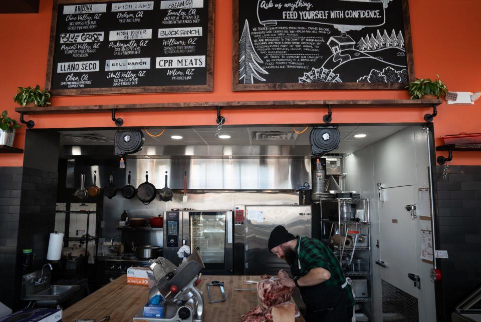 Dustin Dahlin butchers a pork shoulder at Underbelly Meat Co. in Phoenix on Dec. 12, 2022.
