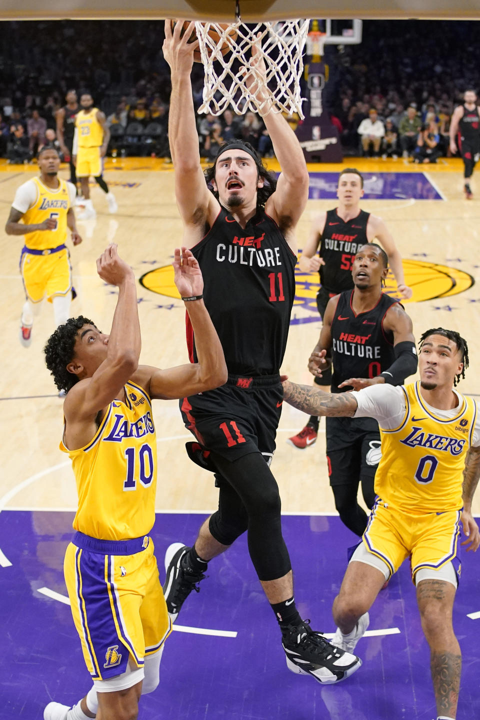 Miami Heat guard Jaime Jaquez Jr. (11) shoots as Los Angeles Lakers guard Max Christie (10) and guard Jalen Hood-Schifino (0) defend during the first half of an NBA basketball game Wednesday, Jan. 3, 2024, in Los Angeles. (AP Photo/Mark J. Terrill)