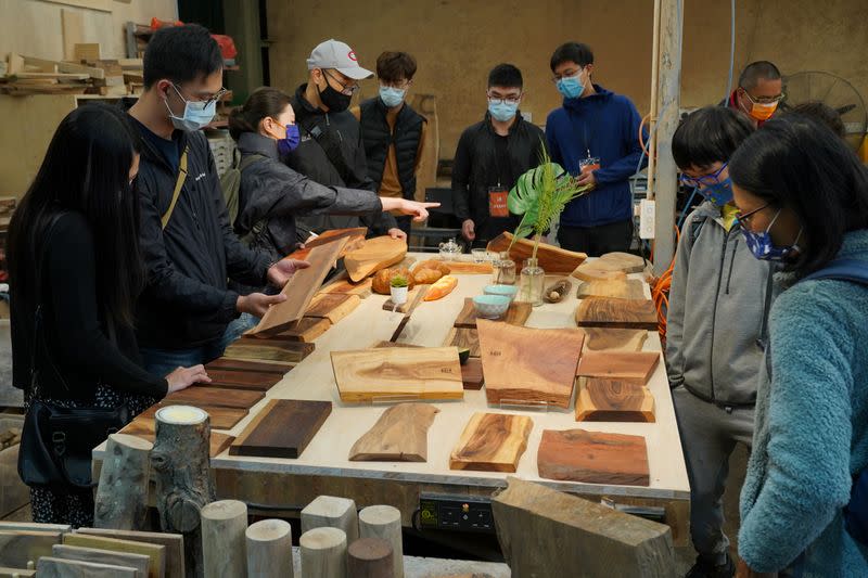 Visitors look at wooden boards displayed at the HK Timberbank factory during an open day, in Hong Kong