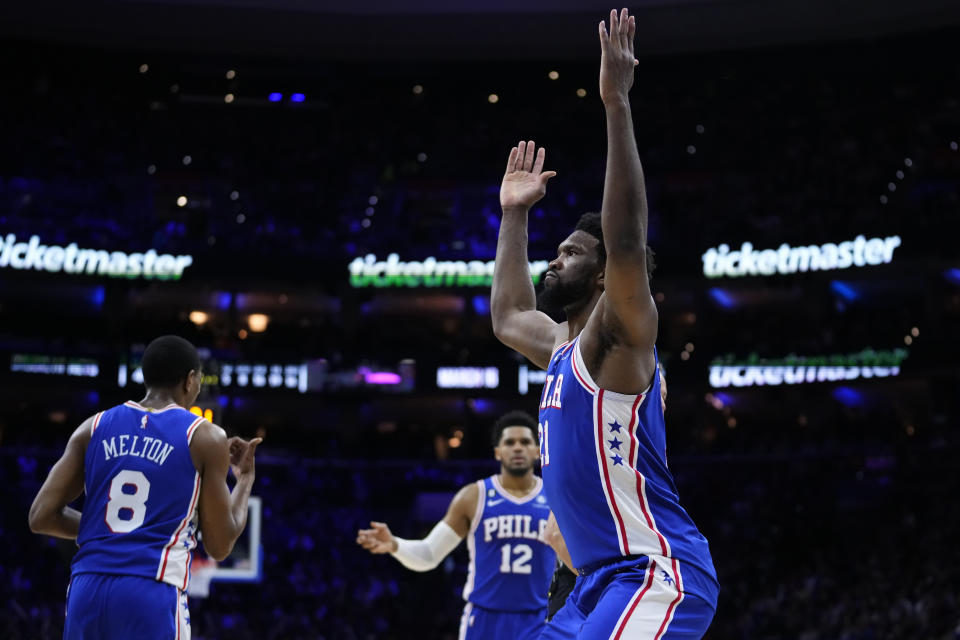 Philadelphia 76ers'  Joel Embiid, right, reacts after making a basket against the Brooklyn Nets, Wednesday, Jan.  25, 2023, in Philadelphia.  (AP Photo/Matt Slocum)