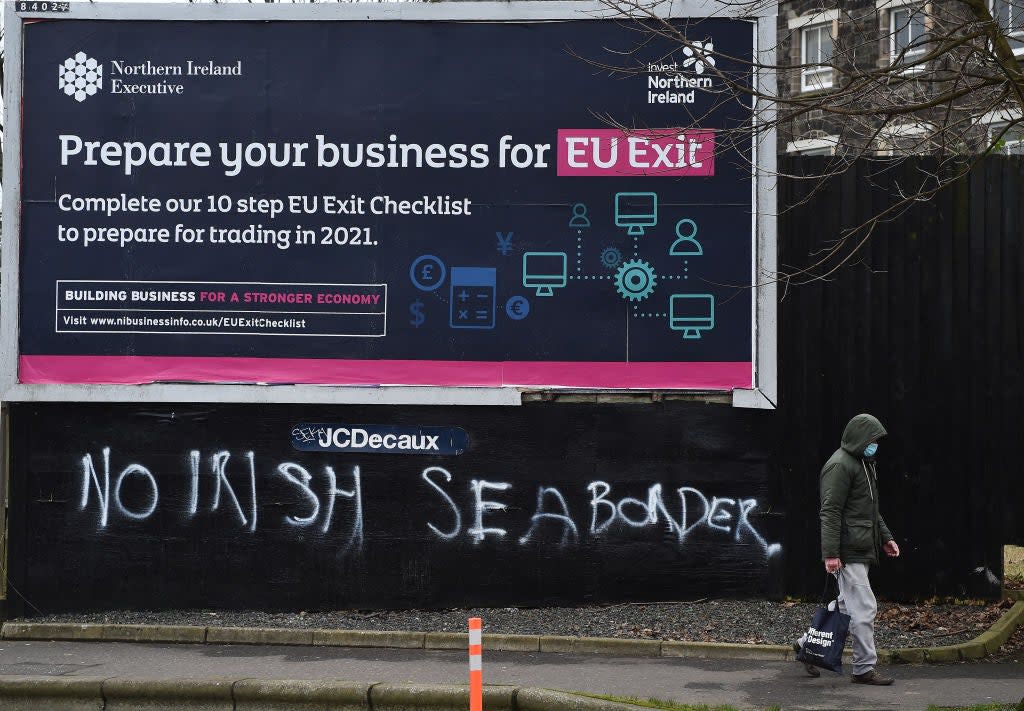  A man walks past graffiti in the loyalist Sandy row area, which reads ‘No Irish sea border’ under an EU Exit billboard on 30 January, 2021 in Belfast. The Police Service of Northern Ireland has been monitoring growing unionist discontent regarding the implementation of a so called Irish sea border (Getty Images)