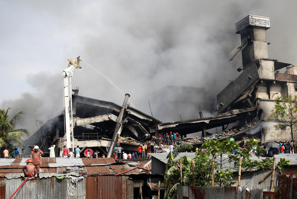 Firefighters extinguish a fire at a food and cigarette packaging factory outside of Dhaka