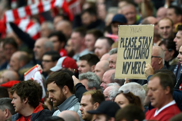 A fan holds up a placard in support of Liverpool's Brazilian midfielder Philippe Coutinho on August 19, 2017