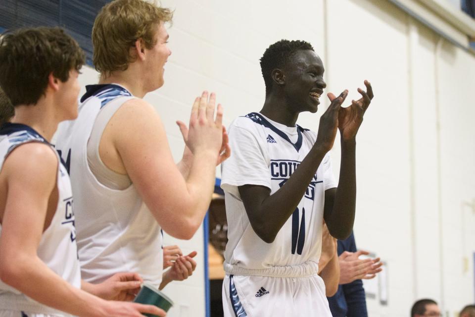 MMU's Taylor Bowen (11) and the bench cheer for the team on the court during the boys basketball game between the Essex Hornets and the Mount Mansfield Cougars at MMU High School on Wednesday night February 13, 2019 in Jericho, Vermont.