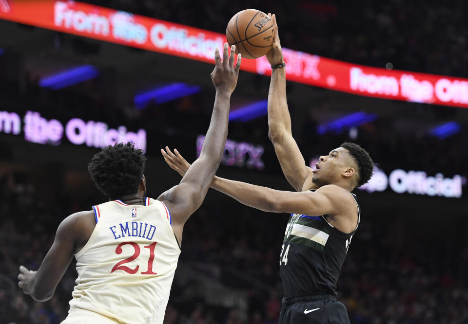 PHILADELPHIA, PENNSYLVANIA - DECEMBER 25: Giannis Antetokounmpo #34 of the Milwaukee Bucks attempts a basket as Joel Embiid #21 of the Philadelphia 76ers defends during the first half of the game at Wells Fargo Center on December 25, 2019 in Philadelphia, Pennsylvania. NOTE TO USER: User expressly acknowledges and agrees that, by downloading and or using this photograph, User is consenting to the terms and conditions of the Getty Images License Agreement. (Photo by Sarah Stier/Getty Images)