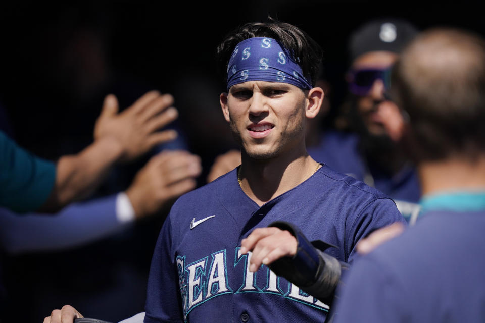 Seattle Mariners' Sam Haggerty is greeted in the dugout after scoring during the fourth inning of a baseball game against the Detroit Tigers, Thursday, Sept. 1, 2022, in Detroit. (AP Photo/Carlos Osorio)