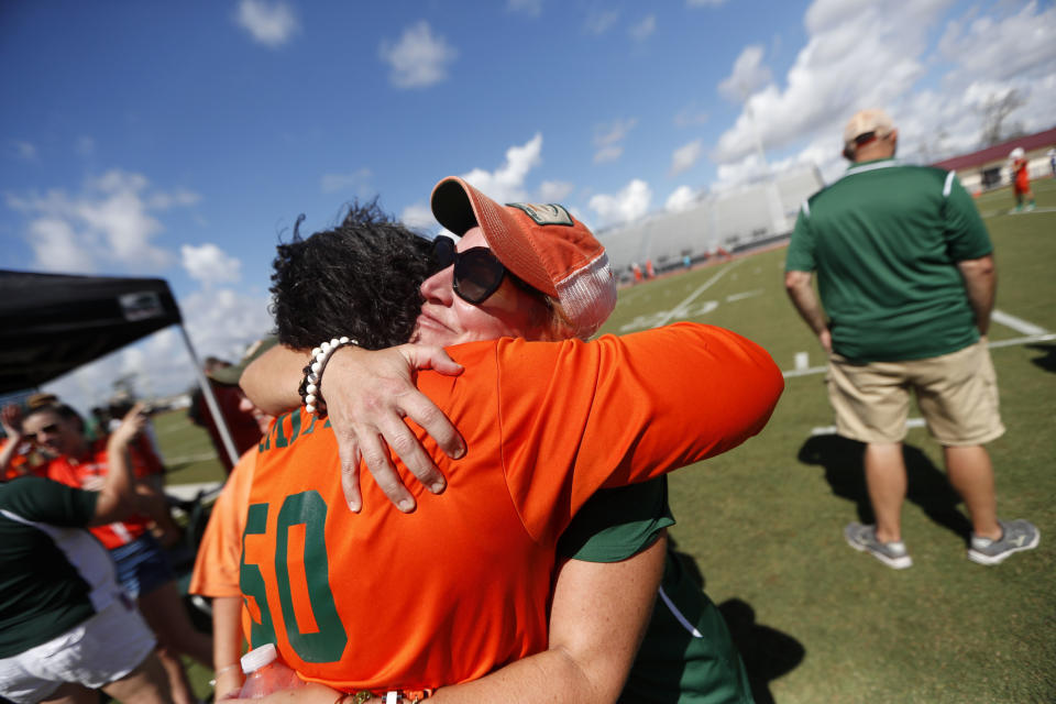 Parents Franlisa Smith, left, and Jan Aker, whose sons are on the Mosley High football team, hug before the start of their game against Pensacola, the aftermath of Hurricane Michael in Panama City, Fla., Saturday, Oct. 20, 2018. (AP Photo/Gerald Herbert)