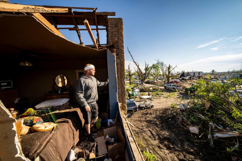 Luke Daughenbaugh looks over tornado damage from his childhood bedroom at his parents house in Greenfield on Wednesday, May 22, 2024.