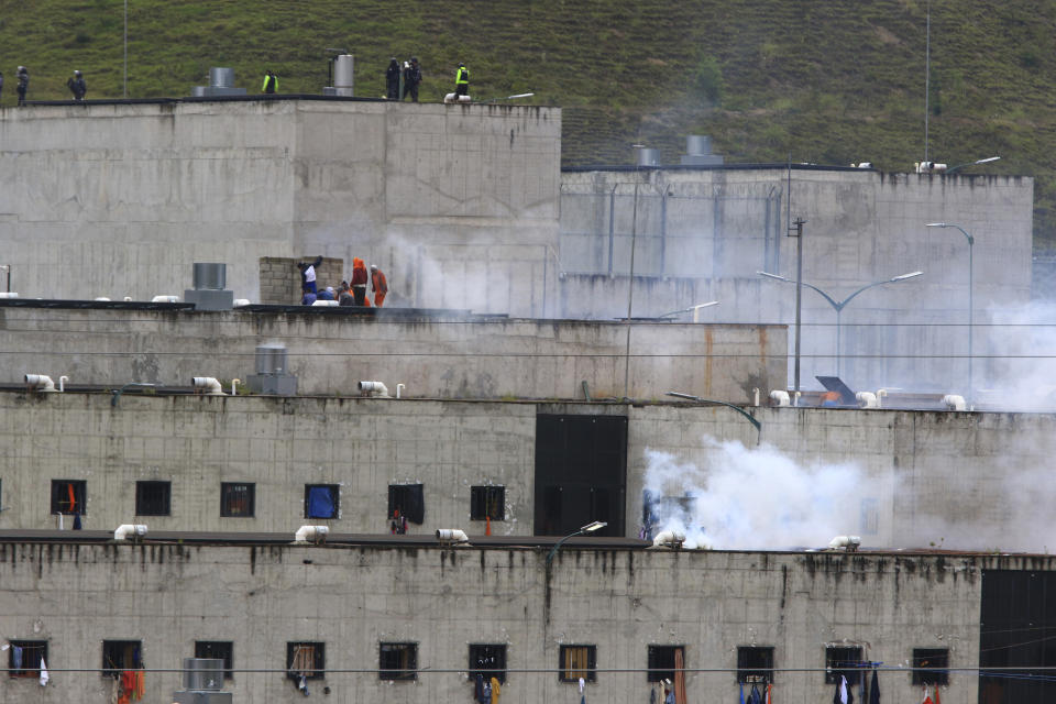 El gas lacrimógeno se eleva desde partes de la cárcel de Turi donde estalló un motín de reclusos en Cuenca, Ecuador, el martes 23 de febrero de 2021. Estallaron disturbios mortales en las cárceles de tres ciudades del país debido a peleas entre bandas rivales, según la policía. (AP Foto/Marcelo Suquilanda)