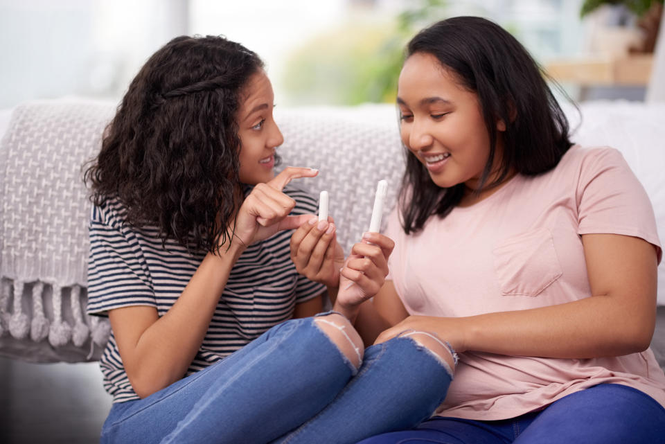 Zwei Mädchen mit Tampons sitzen auf einem Sofa