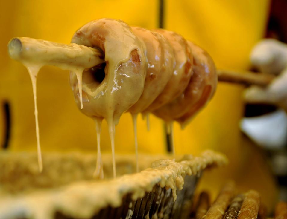 Maple doughnuts are coated with glaze at the Sugar Tree Country Store in McDowell on Saturday. Thousands of people flocked to Monterey and McDowell for the opening day of the Highland County Maple Festival on Saturday, March 10, 2012.