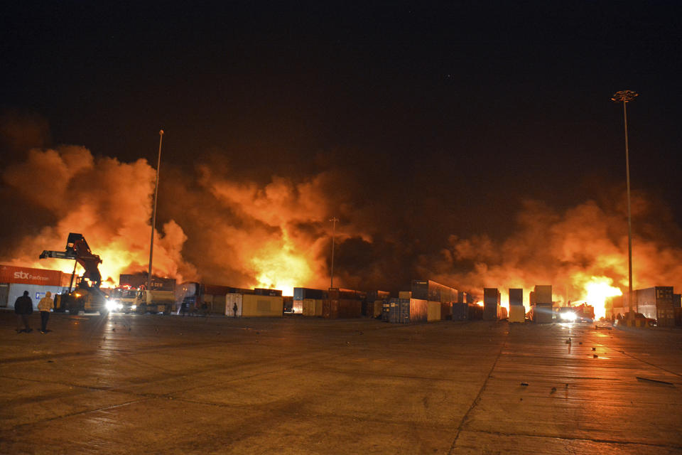 In this photo released by the Syrian official news agency SANA, flames and smoke rise from burning containers at the scene of a missile attack, at the seaport of the coastal city of Latakia, Syria, early Tuesday, Dec. 28, 2021. Israeli missiles fired from the Mediterranean struck the Syrian port of Latakia early Tuesday, igniting a fire in the container terminal, Syrian state media reported, in the second such attack on the vital facility this month. (SANA via AP)